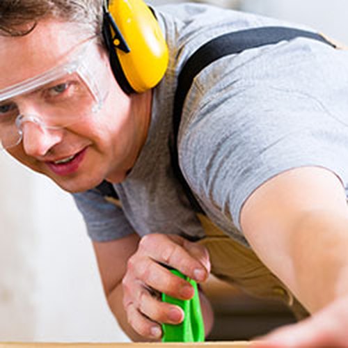 Man met gehoorbescherming aan het werk
